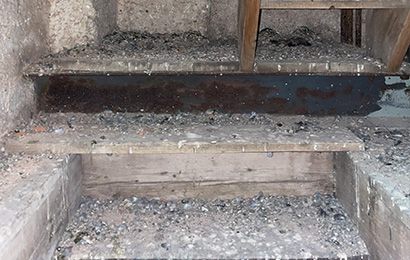 Vorher / Nachher-Aufnahme einer von Taubenkot beschmutzen bzw. gereinigtem Holztreppe in einem Dachstuhl